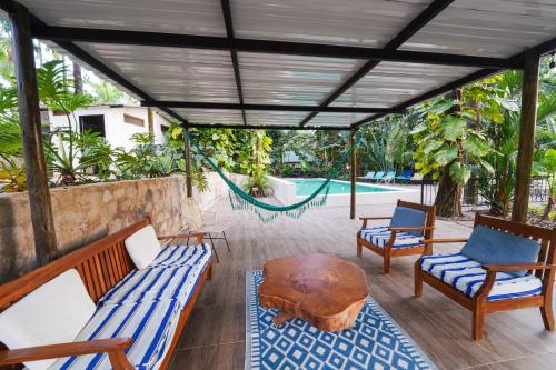 um pátio com 2 sofás, uma mesa e uma piscina em Casa Cumbres Ecolodge em Yopal