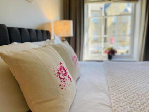 a bed with white sheets and pillows with a window at Pass the Keys Cobblers Rest Luxury Elegance & Central Location in Bakewell
