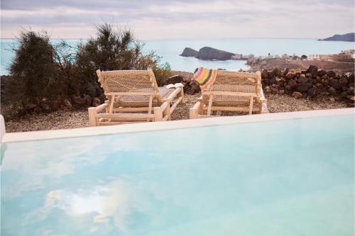 duas cadeiras sentadas ao lado de uma piscina em Cortijo La Loma em La Isleta del Moro