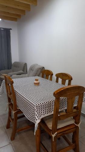 a dining room table with four chairs and a couch at Sueños Del Pilar II in Godoy Cruz