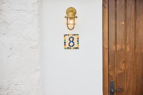 een licht op een witte muur naast een deur bij Cortijo La Loma in La Isleta del Moro