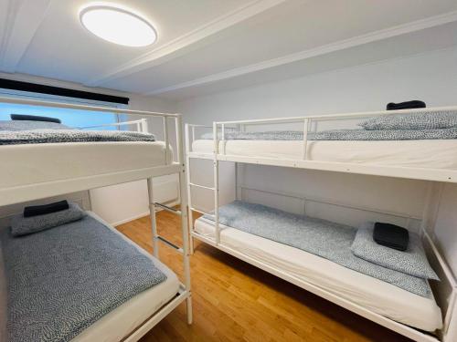 a room with three bunk beds and a light at Central Economic Stavanger in Stavanger