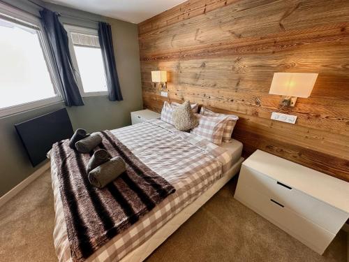 a bedroom with a wooden accent wall and a bed at Large central apartment for 10 by Avoriaz Chalets in Avoriaz
