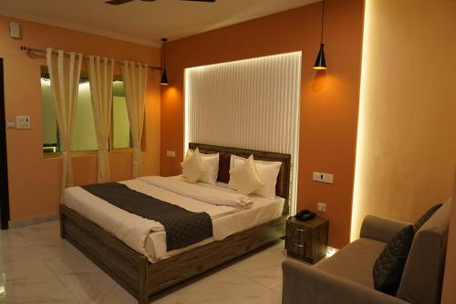 sypialnia z dużym łóżkiem i kanapą w obiekcie Ganeshwaram Hotel & Restaurant Bhowali Uttarakhand w mieście Bhowāli