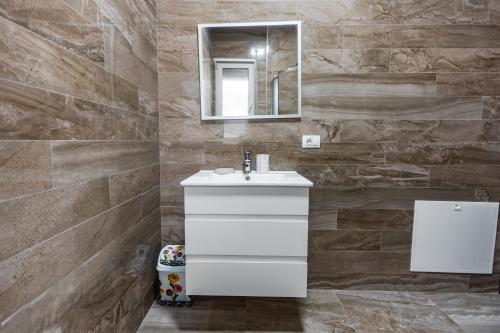 W łazience znajduje się biała umywalka i lustro. w obiekcie The Urban Villa w Szkodrze