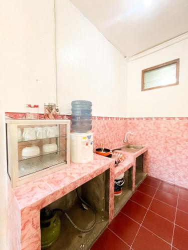 uma cozinha com um balcão e um lavatório num quarto em Villa Pakem em Bedoyo