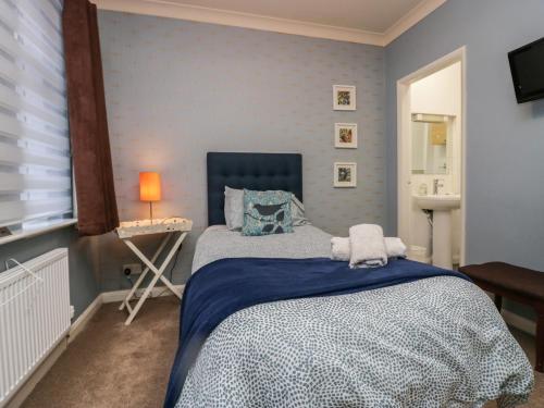 ボウネス・オン・ウィンダミアにあるSandownのベッドルーム1室(青い掛け布団付きのベッド1台付)