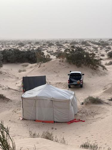 a tent and a car in the desert at Private Camp25km-from DOUZ in Douz
