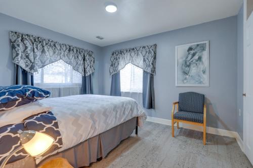 um quarto com paredes azuis e uma cama e uma cadeira em Kalamazoo Vacation Rental Near Golf and Parks! em Kalamazoo