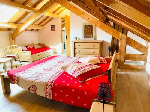 ein Schlafzimmer mit einem roten Bett im Dachgeschoss in der Unterkunft GITE COSTE BELLE in Pont-du-Fossé