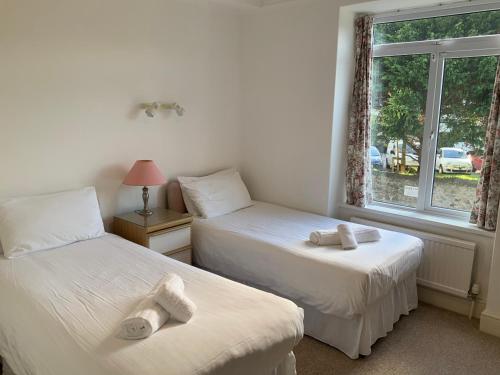 a bedroom with two beds with towels on them at St Merryn in Carbis Bay