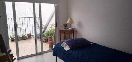 1 dormitorio con cama azul y ventana grande en be en 