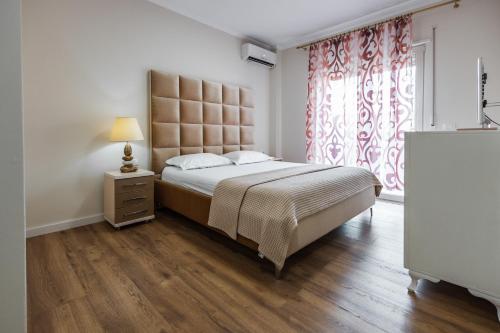 Un dormitorio con una cama grande y una ventana en The Urban Villa, en Shkodër