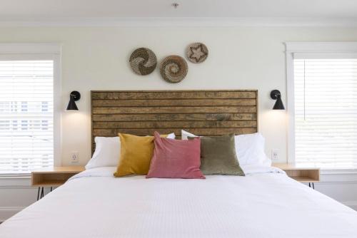 a bedroom with a white bed with colorful pillows at Avamere 206 Inn at Old Beach in Virginia Beach