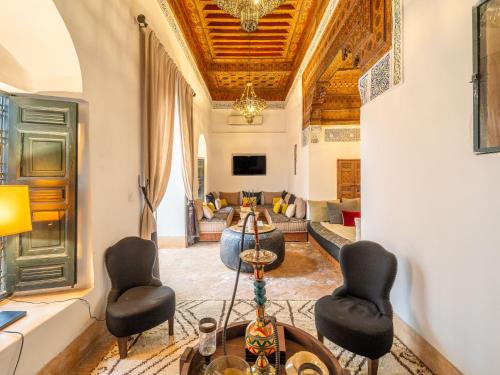 a living room with a couch and a table and chairs at Dar Assiya in Marrakech