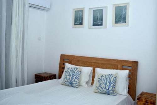 a bedroom with a bed with blue and white pillows at Kensington Square Luxury Apartment in Flic-en-Flac