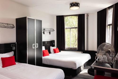 a hotel room with two beds and a fan at BackStage Hotel in Amsterdam