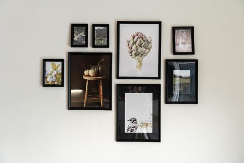 a group of framed pictures on a wall at Pomegranate Luxury Penthouse Maisonette with Stunning Terrace #Free Parking# by BiNoBi! in Thessaloniki