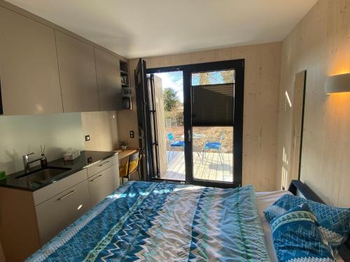 1 dormitorio con 1 cama y cocina con ventana en Auf Wolke 7 - Gäste-Studio im Mini House, en Aeschi
