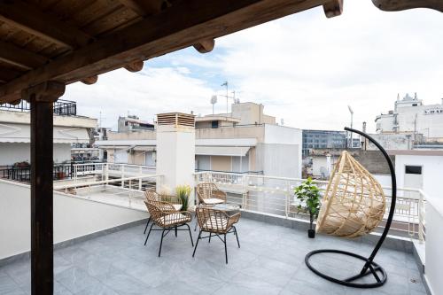 a balcony with chairs and a table on a roof at Pomegranate Luxury Penthouse Maisonette with Stunning Terrace #Free Parking# by BiNoBi! in Thessaloniki