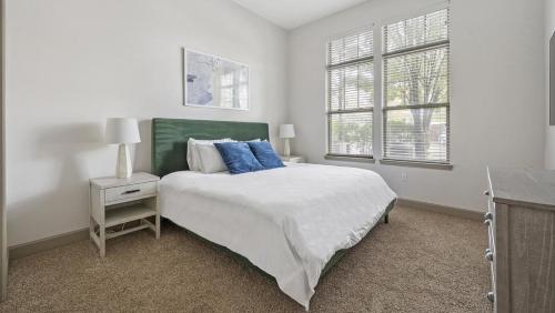 een witte slaapkamer met een bed en een raam bij Landing - Modern Apartment with Amazing Amenities (ID2269) in Franklin