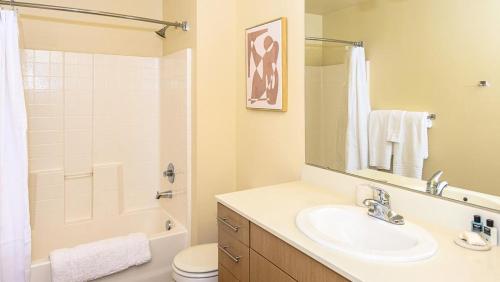 a bathroom with a sink and a toilet and a mirror at Landing - Modern Apartment with Amazing Amenities (ID8687X92) in Tacoma