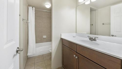 y baño blanco con lavabo y ducha. en Landing - Modern Apartment with Amazing Amenities (ID1316X116), en Bethesda