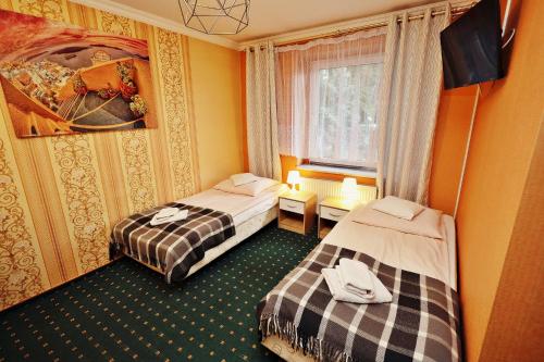 a hotel room with two beds and a window at Bed&Breakfast Maciejanka in Kobyla Góra