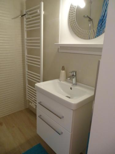 uma casa de banho com um lavatório branco e um espelho. em Ferienwohnung am Pilsensee em Seefeld