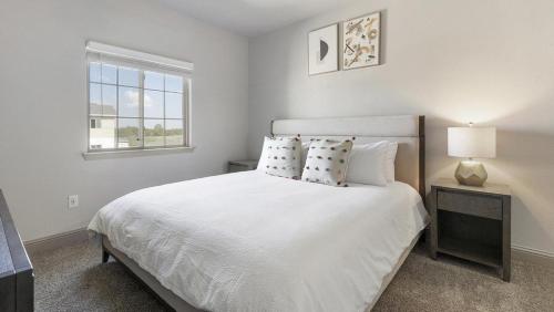 a white bedroom with a bed and a window at Landing - Modern Apartment with Amazing Amenities (ID1215X775) in Burleson