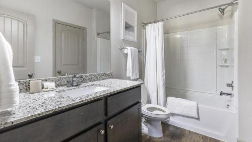 a bathroom with a sink and a toilet and a shower at Landing - Modern Apartment with Amazing Amenities (ID1215X775) in Burleson