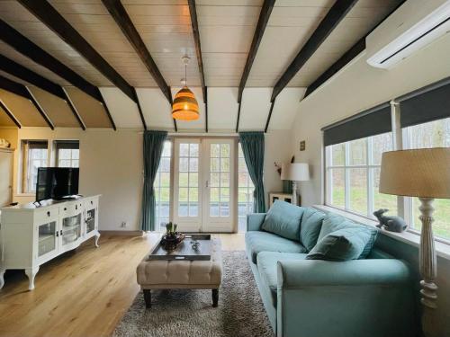 a living room with a blue couch and a table at Natuurhuisje - Gastenverblijf De Kleine Hazerij in Wijhe