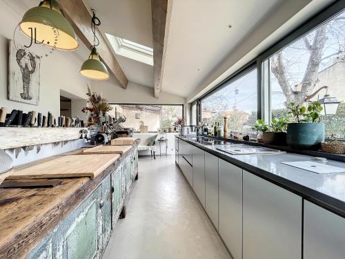 une cuisine avec des placards blancs et une grande fenêtre dans l'établissement La villa Paradis, à La Seyne-sur-Mer