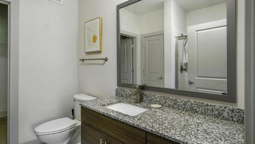 a bathroom with a toilet and a sink and a mirror at Landing - Modern Apartment with Amazing Amenities (ID6167X30) in Richmond