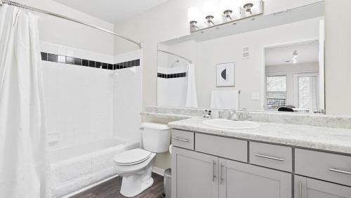 ein weißes Bad mit einem WC und einem Waschbecken in der Unterkunft Landing - Modern Apartment with Amazing Amenities (ID8245X00) in Winston-Salem