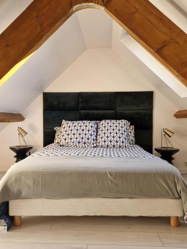 une chambre avec un grand lit avec une tête de lit noire dans l'établissement Le Duplex, proche centre-ville, à Quimper