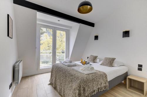 une chambre blanche avec un lit et une fenêtre dans l'établissement 321 Suite New Delhi - Superbe appartement, à Suresnes