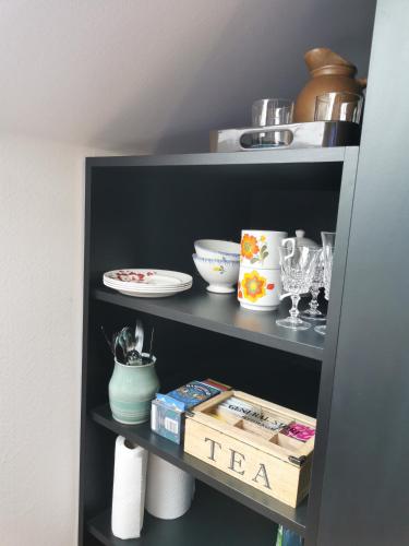 a black shelf with bowls and dishes on it at Studio spacieux, route des vins in Rosheim