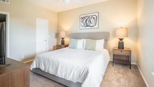 a bedroom with a bed and two night stands with lamps at Landing - Modern Apartment with Amazing Amenities (ID8246X10) in Tulsa