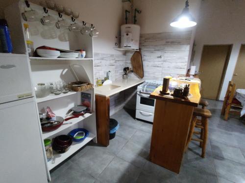 a kitchen with a counter and a sink and a stove at Complejo Turístico PET Friendly Los Abuelos- Cabaña ENCANTO NATURAL. in Cholila