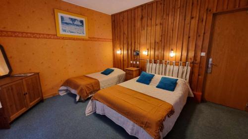 a hotel room with two beds and a television at Le Vieux Tilleul in Seyne