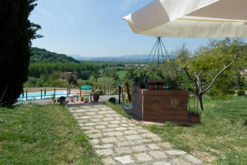 a white umbrella sitting on a stone walkway at Podere Chiaromonte in Palaia