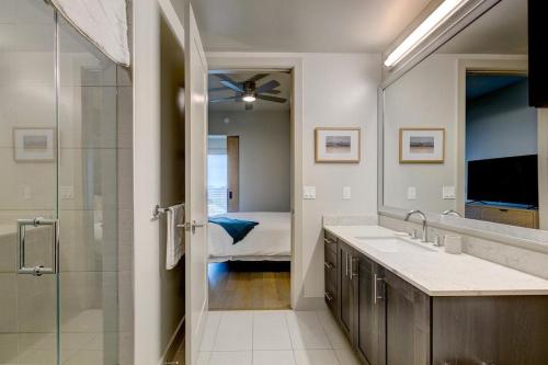 a bathroom with a sink and a shower and a bedroom at Landing - Modern Apartment with Amazing Amenities (ID4772X11) in Dallas