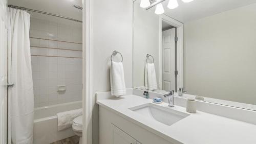 een witte badkamer met een wastafel en een spiegel bij Landing Modern Apartment with Amazing Amenities (ID9265X68) in Denver
