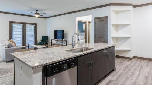 una cucina con lavandino e un soggiorno di Landing - Modern Apartment with Amazing Amenities (ID6605X81) a Louisville