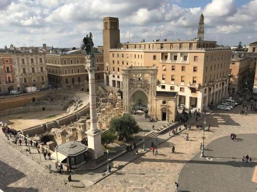 a large building with a statue in front of it at Mammasisi Rooms in Lecce