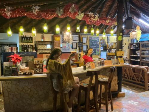 two women sitting at a bar in a store at Casa Encuentro Ecolodge in Guatapé