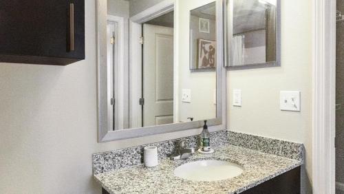 ein Bad mit einem Waschbecken und einem Spiegel in der Unterkunft Landing - Modern Apartment with Amazing Amenities (ID2396X34) in Baton Rouge
