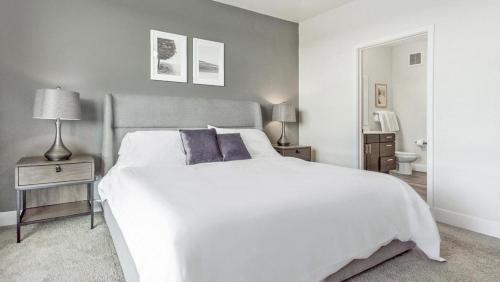 um quarto com uma grande cama branca e 2 almofadas em Landing - Modern Apartment with Amazing Amenities (ID5507X06) em Denver