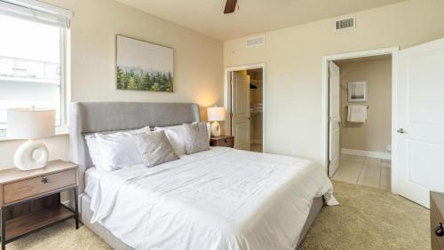 een slaapkamer met een groot wit bed en een raam bij Landing - Modern Apartment with Amazing Amenities (ID7823X09) in Miami